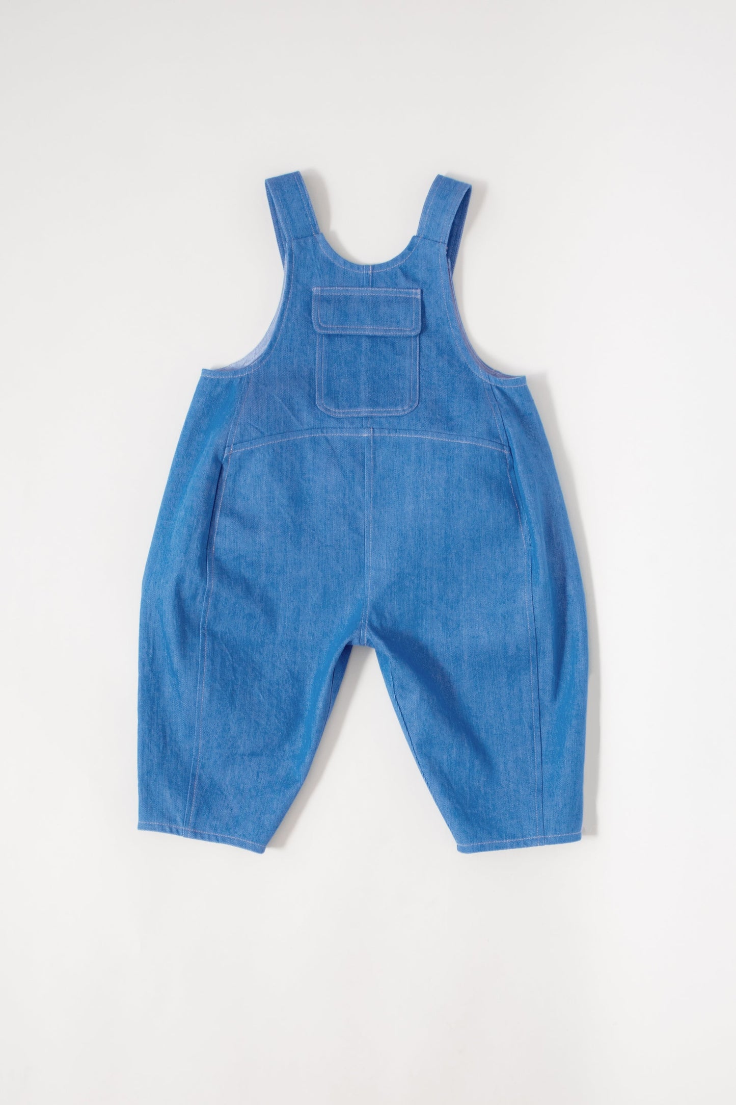 Studio Koter Kai Denim Dungarees front view showing oversized fit and curved seam details on sustainable kids clothing