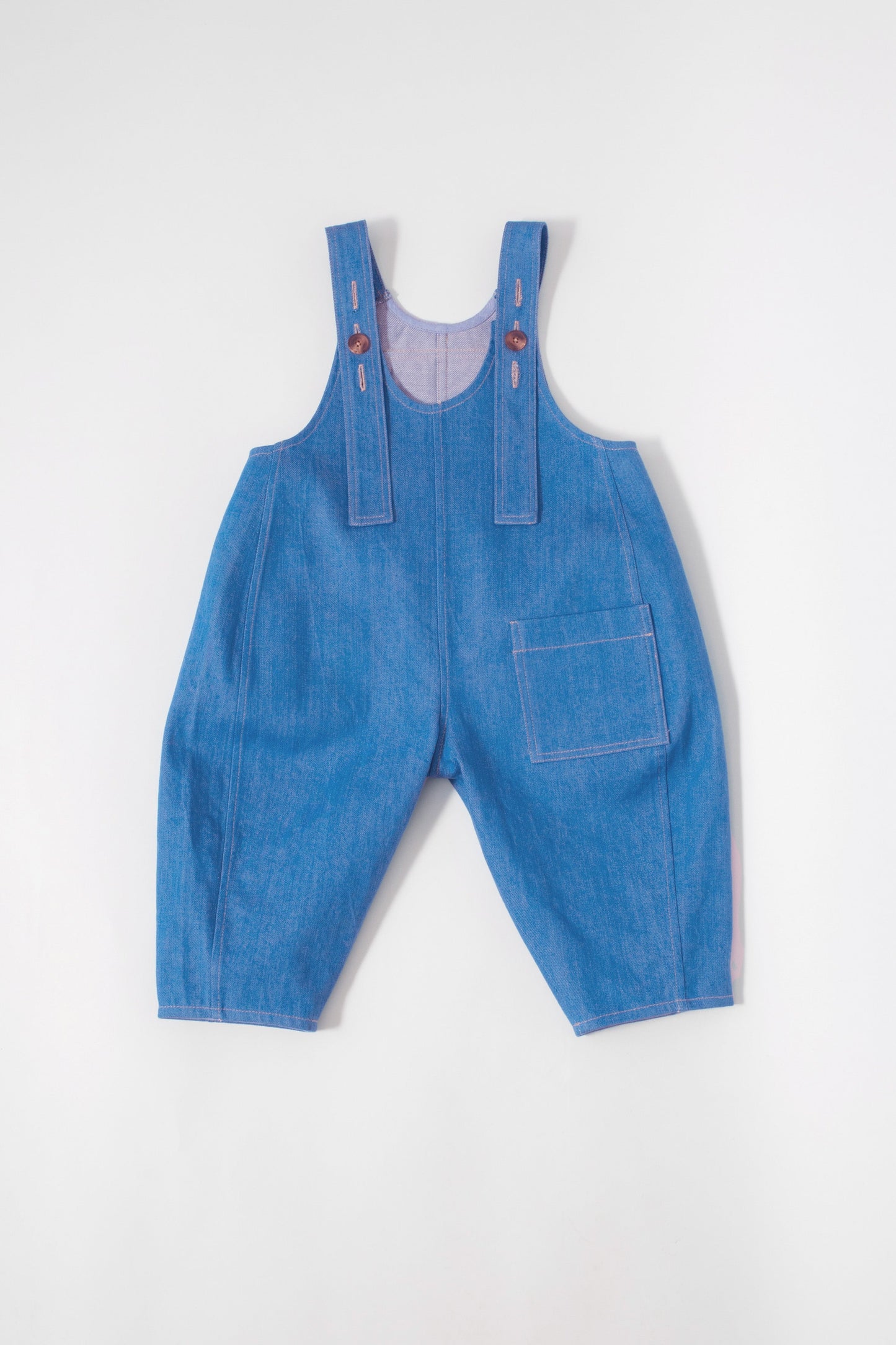 Back view of Kai organic cotton dungarees featuring utility pockets and adjustable straps
