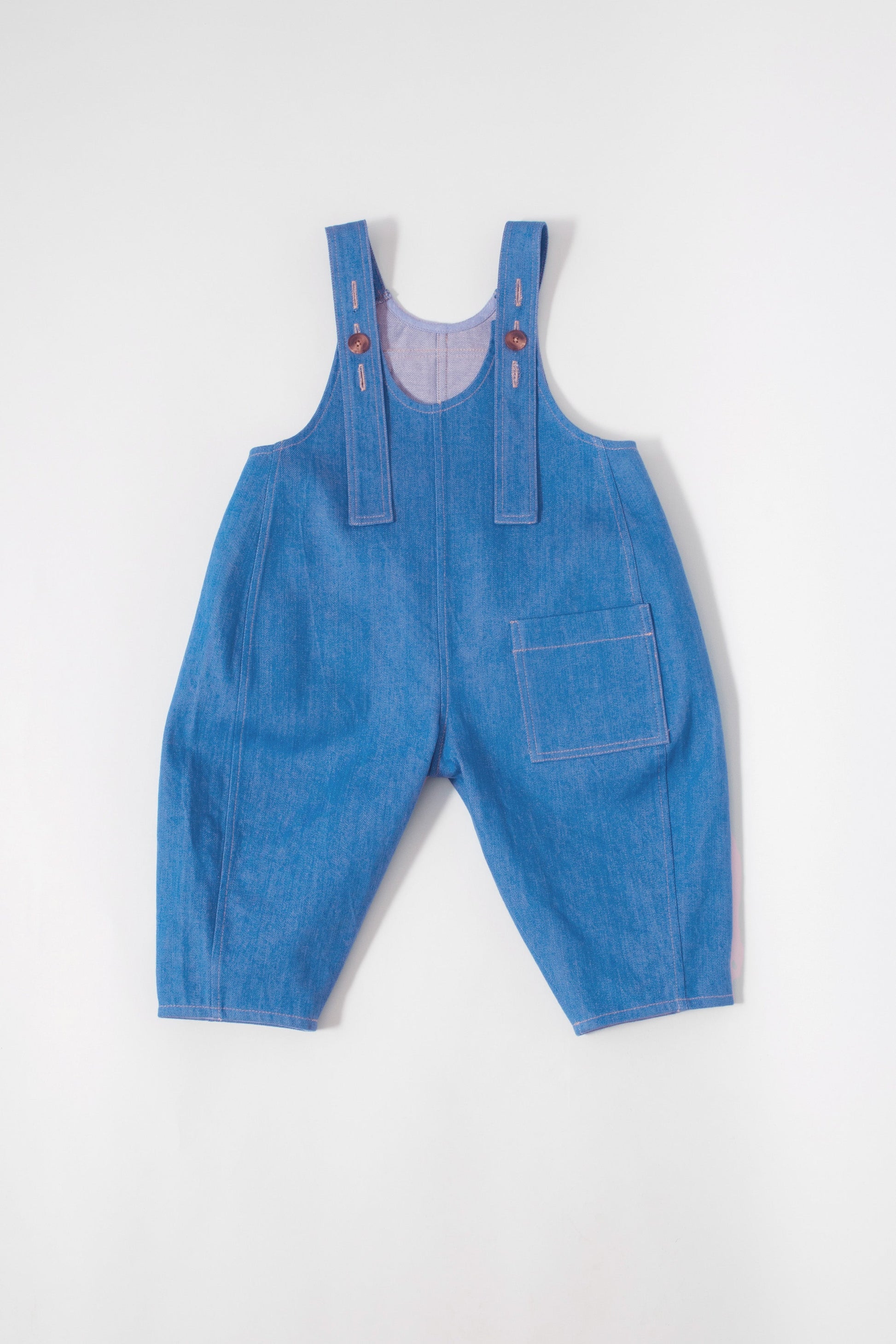 Back view of Kai organic cotton dungarees featuring utility pockets and adjustable straps